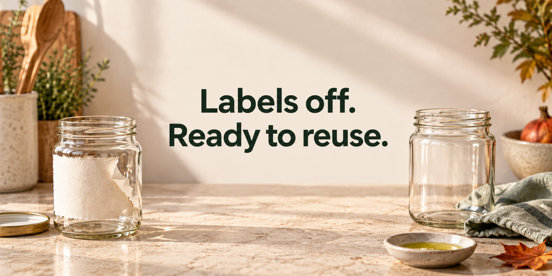 A jar with a partly removed paper label beside a clean jar, cloth and small oil dish; title: Labels off. Ready to reuse.